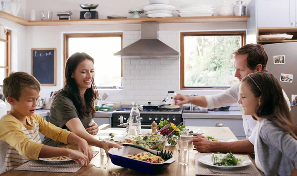 不仅仅是分享食物 还有爱 两个有爱心的年轻父母和他们的孩子在家里厨房里吃饭 — 图库照片
