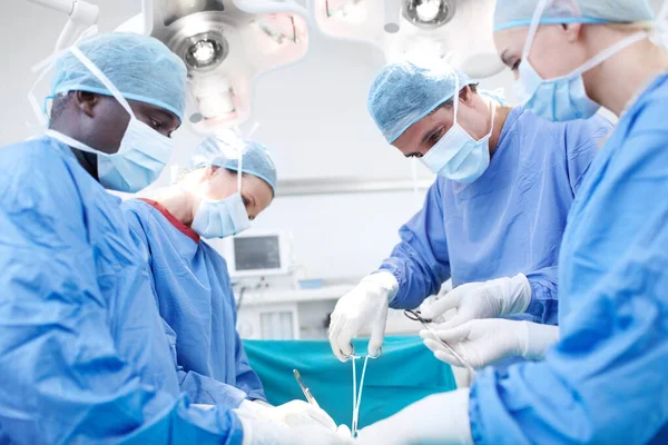 把你的生命交给好的人外科医生给病人做手术的侧视图 — 图库照片