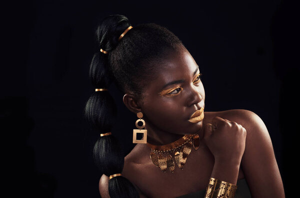 Gold, beauty and black woman in studio for makeup, art and elegance against a black background. Rich, creative and African female model pose with jewelry for wealth, royal and luxury queen aesthetic.