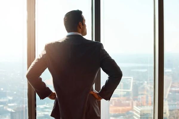 stock image Business man, building and window for thinking of ideas, future plan or vision by cityscape. Professional male executive with hands on hips for inspiration, dream or corporate development from behind.