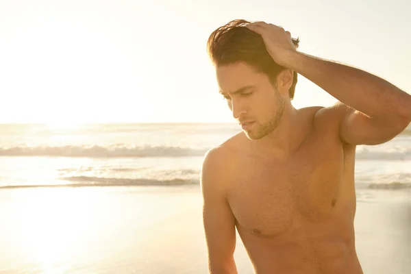 ビーチで一人で時間 夕暮れ時に浜に立つハンサムな白人青年 — ストック写真