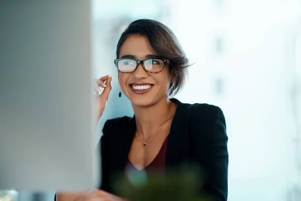 Business woman, happy and computer in glasses reflection for reading, online review and editor analysis or news. Smile of biracial person or professional worker with website or results on desktop pc.