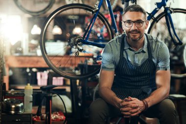 Portre, gülümseme ve bisiklet dükkanında, mağazada ya da bisiklet tamir atölyesinde teknisyen. Yüz, bisiklet tamircisi ve erkek, kendine güvenen iş sahibi ya da gözlüklü olgun bir profesyonel.