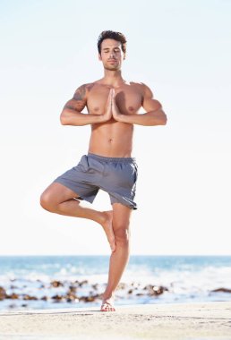 Spor, insan ve yoga plajda egzersiz, ruhsal sağlık veya doğada iç huzur için meditasyonda. Ağaçtaki sakin erkek yogi denge, sağlıklı vücut ya da okyanusun farkındalığı için poz verir..