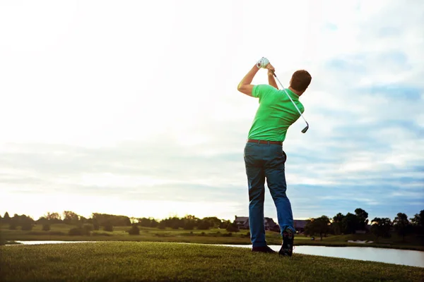 姿勢を改善し スイングを向上させます ゴルフ場でスイングの練習をしている男が — ストック写真