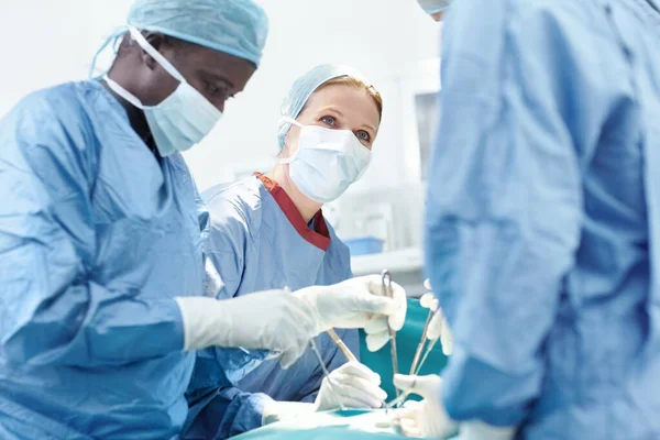 一个相互信任 不同组的外科医生在急诊室为病人做手术 — 图库照片