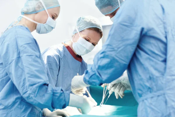 医疗人员在工作 外科医生使用医疗工具和钳对外科手术中的病人进行手术 — 图库照片