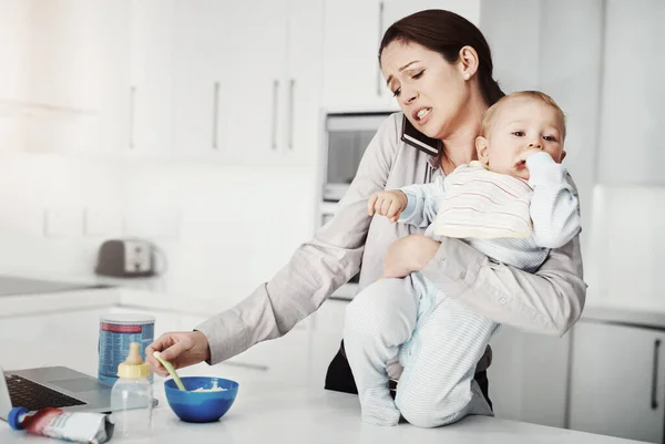 stock image Frustrated, baby and mother busy multitasking in home with phone, food and work or childcare, stress and pressure. Mom, newborn boy and overwhelmed with no support, partner or working single parent.