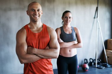 Mutlu insanlar, spor salonunda spor yapmak, egzersiz yapmak ya da antrenman yapmak için kolları bağlı kişisel antrenör portresi ve spor salonu. Güçlü, zinde ve kendine güvenen erkek ve kadın egzersiz sınıfına hazır..