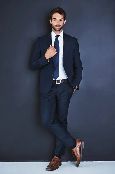Portrait, fashion and a formal business man in studio on a blue background for contemporary corporate style. Success, professional and a confident young male employee in a suit for executive power.