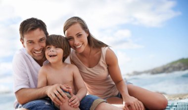 Mutlu bir aile, çocuk ve yaz tatili için sahilde çekilmiş bir portre. Gülümseme ve eğlenceyle. Bir erkek, kadın ve çocuk ya da oğul tatilde, macerada ya da mavi gökyüzü ve mutlulukla denizde piknikte.