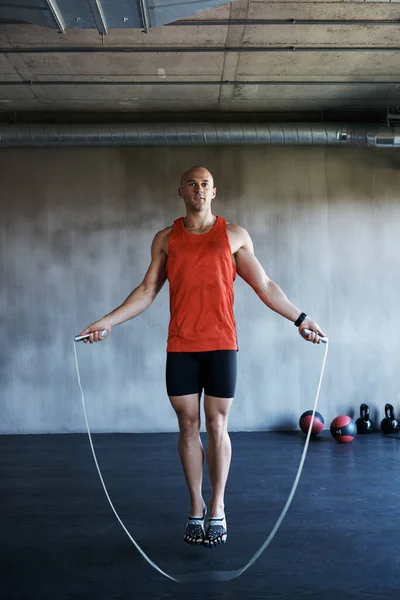 Keep it going. Fitness, jump rope and portrait of man doing gym training, cardio endurance challenge or exercise performance. Skipping, active lifestyle and male sports person doing jumping workout