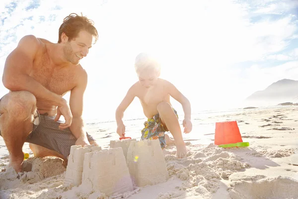 お父さんと私は砂の城を建てる 若い父親と息子が砂浜に砂の城を建て — ストック写真