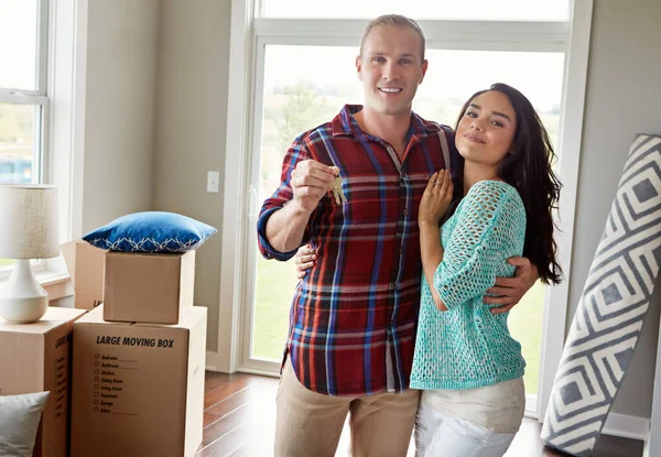 Real estate, keys and new home or couple hug for mortgage or property buy and happy portrait together with boxes in lounge. Apartment, man and woman excited for rent or in love or embrace for move.
