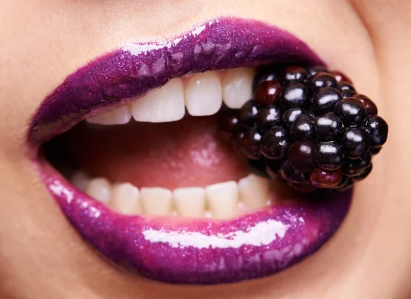 女性唇特写 紫色唇膏与黑莓和化妆品 光泽和创造力与美丽 女模牙齿 化妆品和化妆品之间的果实 嘴部有光泽唇彩 — 图库照片