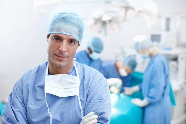我的团队是世界级的 一个严肃的外科医生站在手术室的画像 — 图库照片