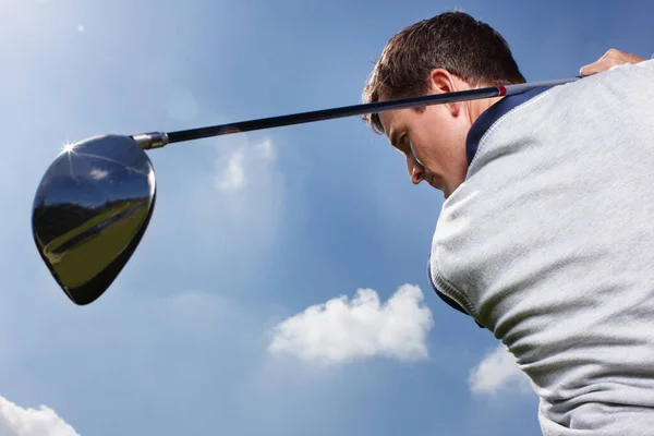 完璧なスイングだ 青い空に対してゴルフのラウンド中にフルスイングで若い男 — ストック写真