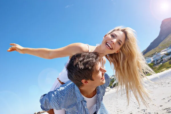 让我的头发失望这个假期 一对快乐的年轻夫妇在海滩上享受着搭便车的乐趣 — 图库照片