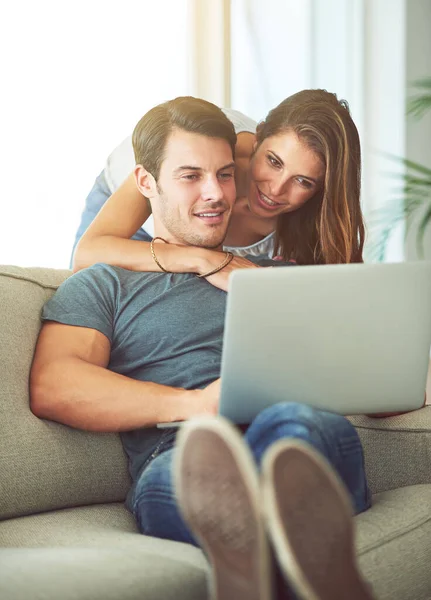 リモートワークやストリーミング映画のためのインターネット中にカップル ラップトップや家庭用ソファに抱擁 オンラインショッピング 検索やインターネット接続について幸せながら 家の中で一緒に男と女 — ストック写真