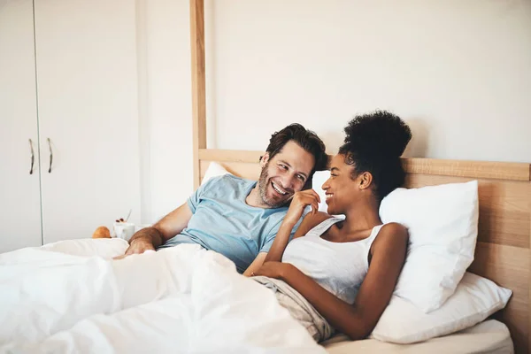 인종간의 유대를 침대에서 긴장을 웃기는 집에서의 미소를 침대에 즐거운 대화를 — 스톡 사진