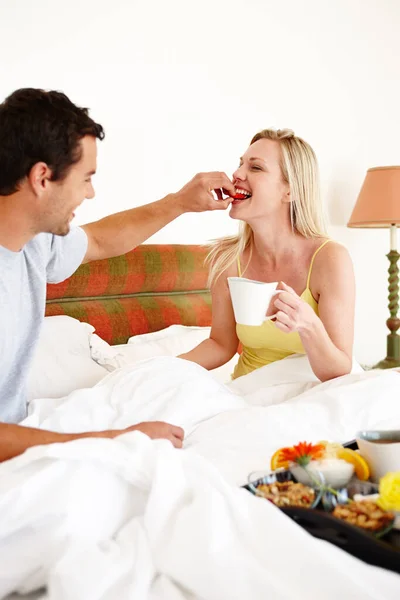 尝尝这个吧 一对快乐的年轻夫妇在床上共进早餐 — 图库照片