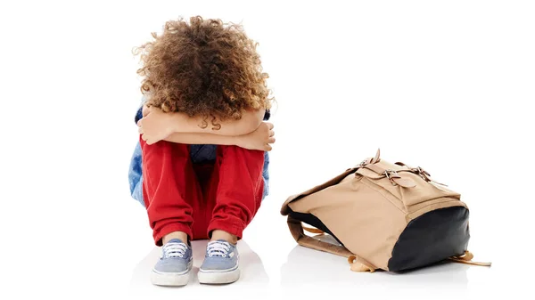 stock image Im not cut out for this school thing. Studio shot of a little boy with his head buried in his knees sitting next to his schoolbag against a white background