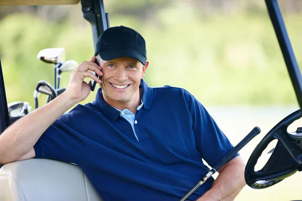 On call wherever you go. Portrait of a man sitting in a golf cart and talking on his cellphone