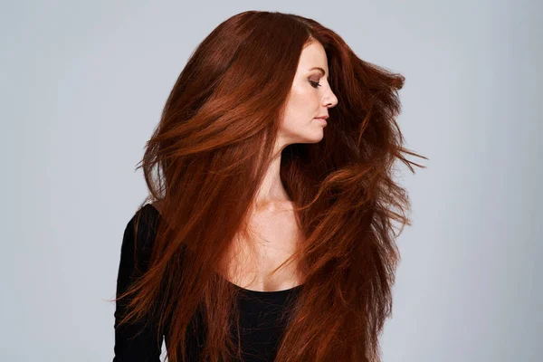 グレーの背景にケラチン治療 ウェルネスとヘアケアのためのスタジオで赤い髪 振ると女性 輝きと美しさ 美容師のモックアップと女性モデル 健康と自然 ジンジャーヘアスタイル — ストック写真