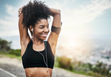 Gülümse, kadın ve kollarını esnet spor, spor ve kardiyo için müzik eşliğinde dışarı koşmak için. Esneme, egzersiz ve mutlu Afrikalı kadın koşucu eğitim koşusu için podcast ile doğada.
