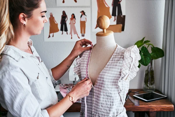Its my passion to make clothes. a young fashion designer working on a garment hanging over a mannequin