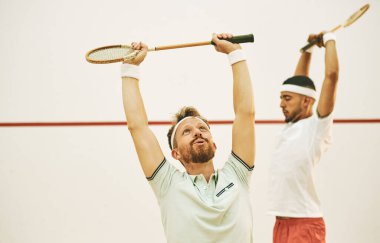 İyi bir ısınma her şeyi değiştirir. İki genç adam squash oynamadan önce geriniyor.