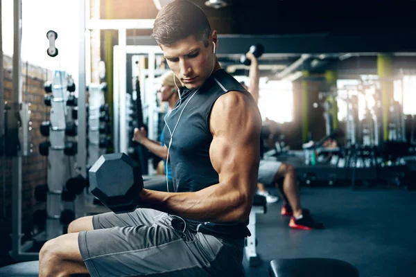 Get focused now. a man doing a upper-body workout at the gym