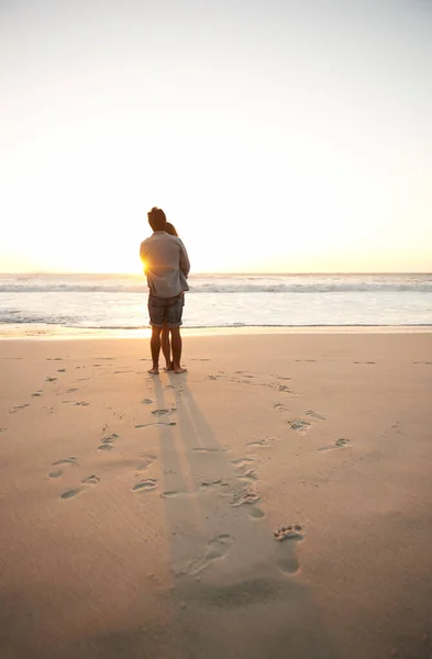 日没時の真の愛 ビーチで一緒に立っている間に夕日を楽しむ若いカップルの後ろの景色 — ストック写真