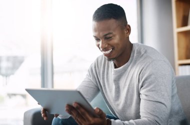 Gülümse, tablet ve mutlu adam kanepede sosyal medya mim, e-posta ya da abonelik hizmeti videosu okuyor. Mutluluk, internet ve ağ kurma, kanepede internetten film sitesini kontrol eden kişi