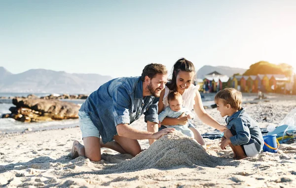 愛とサポートとビーチでの砂の城の楽しさ 親と子供 海と海と家族で幸せと笑顔で太陽の下で遊んでいる子供たちと一緒に赤ちゃん お母さんとお父さん — ストック写真