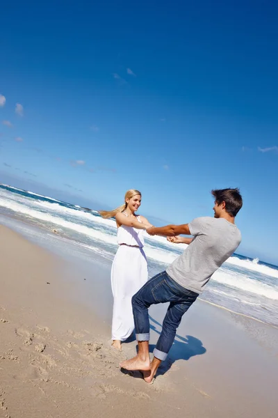 大海让他们的爱情自由了 一对快乐的年轻夫妇在海滩享受着欢乐的时光 — 图库照片