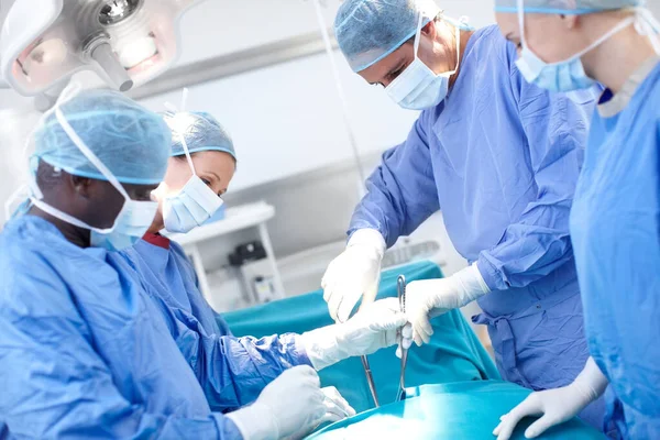 我们对人体了如指掌 在手术室为病人工作的一组医生和外科医生 — 图库照片