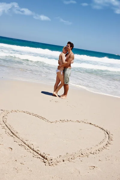 沙子和感情 一对年轻夫妇在沙滩上享受一段浪漫的时光 旁边是在沙滩上心动的图画 — 图库照片