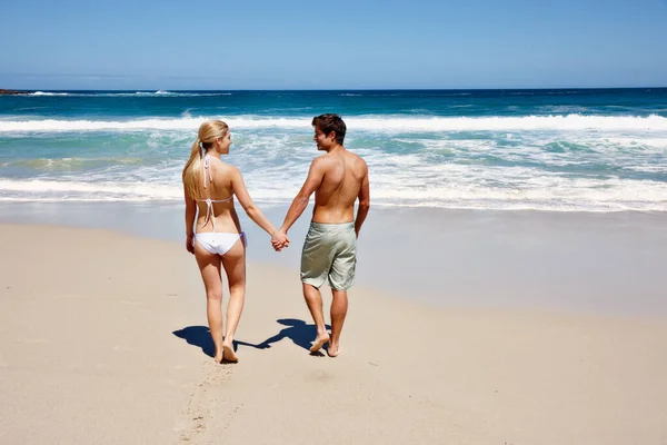 一个美丽爱情的开始一对快乐的年轻夫妇手牵手在海滩上的背景照片 — 图库照片