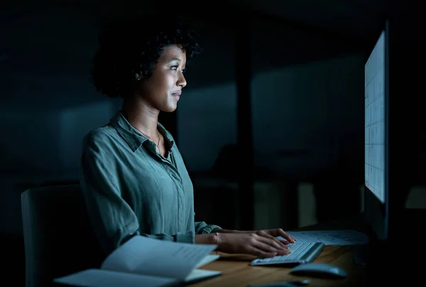 Dig deep and get things done. a young businesswoman using a computer during a late night at work