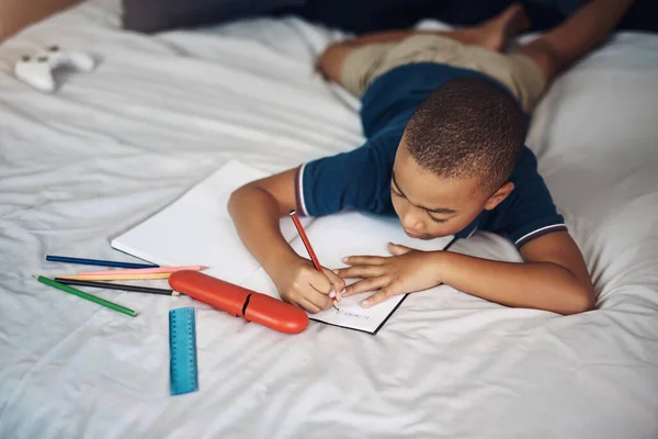 他总是不请自来地做作业 一个在家里用铅笔写字的小男孩 — 图库照片