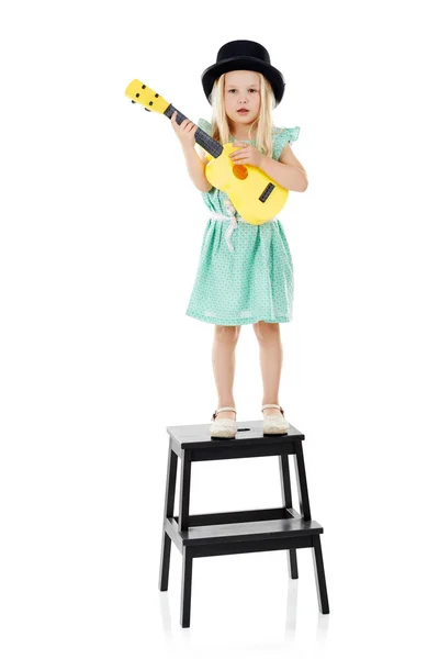 ジャジージュニア スタジオショットの可愛いです女の子遊びとともに彼女のおもちゃのギターのために白い背景 — ストック写真