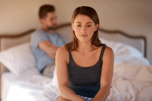 Sad, upset and couple in an argument in their bedroom for divorce or breakup in a modern house. Toxic, mad and face of a woman fighting and in conflict with her boyfriend in bed in their home