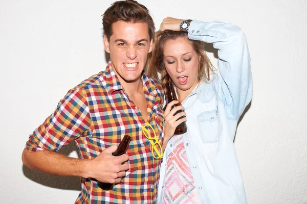 Portrait of gen z couple at party, beer and drunk face, hipster fashion with university youth culture. Drinks, woman and man in crazy picture at college event, happy friends on white wall background