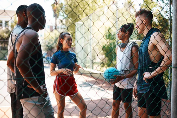 stock image They all speak the language of basketball. a group of sporty young people chatting on a sports court