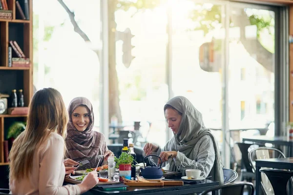 朋友们 快乐的穆斯林妇女在餐馆里 一起吃饭 一起聊天 微笑和伊斯兰女孩 团体或人们聊天 谈话和讨论 以促进社交聚会 联系和食物 — 图库照片