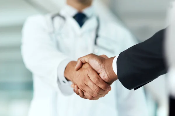 stock image Closeup, doctor or man with handshake, negotiation or planning with partnership, healthcare or wellness. Medical professional, consultant or employee with an offer, support or teamwork with promotion.