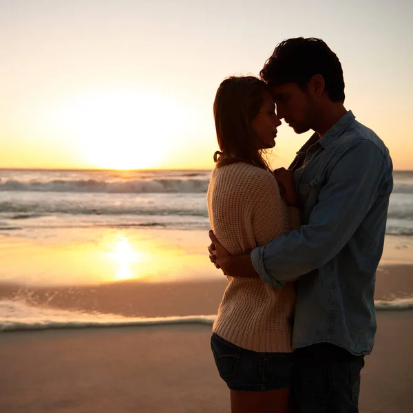 日没時の情熱 日没時にビーチで抱き合っている若いカップルが — ストック写真