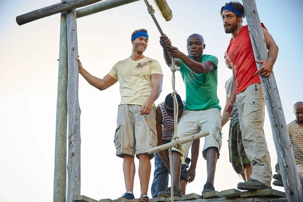 stock image There to motivate each other. a group of men going through an obstacle course at bootcamp