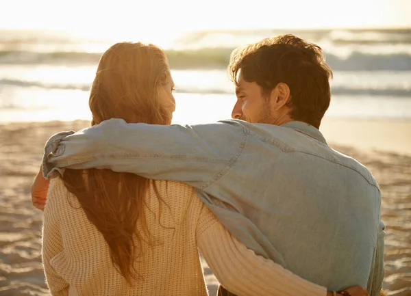 太陽が沈むのを待っている ビーチに座ってロマンチックな瞬間を共有する若いカップルのリアビューショット — ストック写真